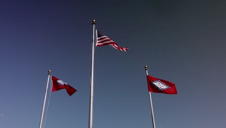 les drapeaux de l'état de l'arkansas et le drapeau américain agitant dans le vent au ralenti