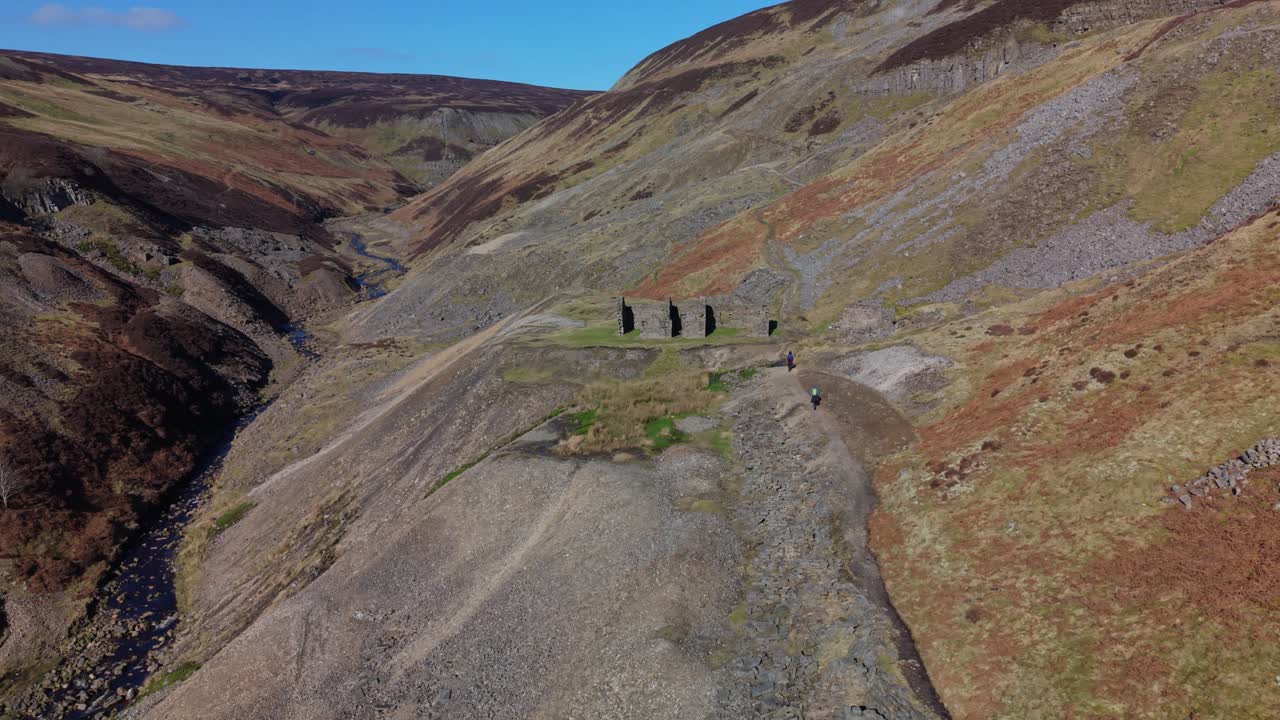 Escursionisti attraversano il pittoresco Gunnerside Gill nello Yorkshire Dales, Inghilterra