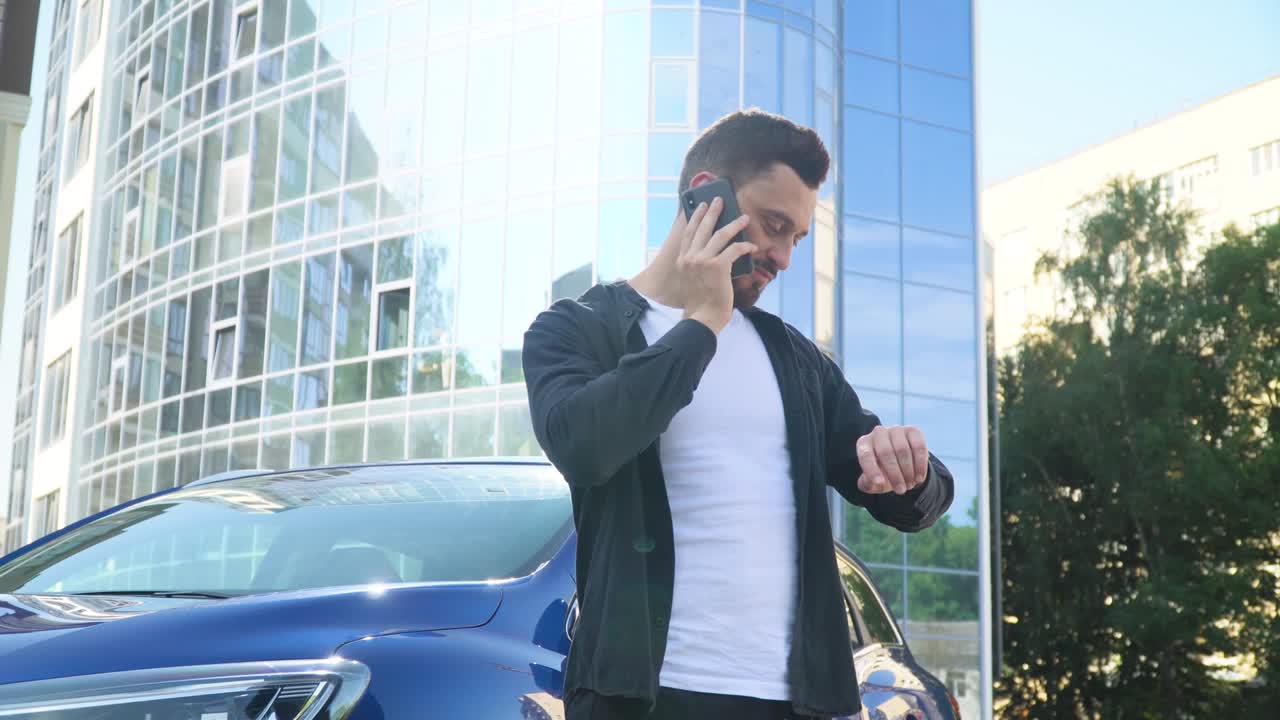 사업가 는 비즈니스 센터 근처 에 있는 스마트폰 에 대화 하는 동안 차 근처 에 서 있다