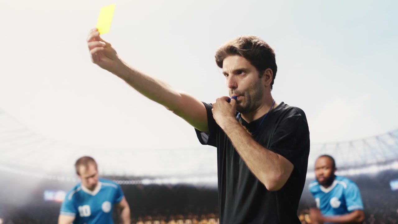 Arbitro di calcio che interrompe un'accesa discussione con il cartellino giallo alzato.
