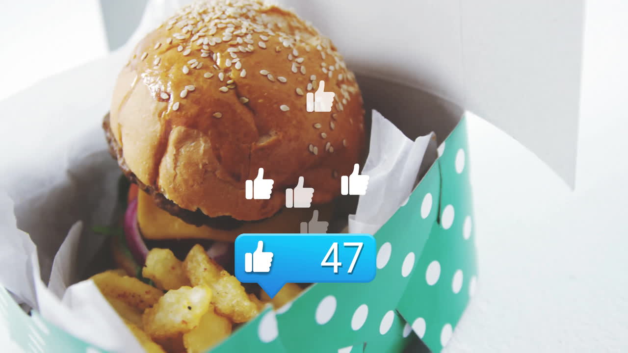 Animation of likes and thumbs-up icons around burger and fries in box