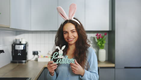 woman holding an easter sign in her kitchen