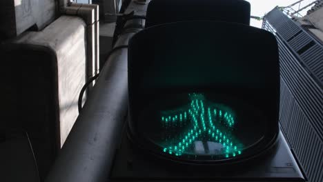 alejándose de una señal de tráfico que indica un paso con una luz verde en las calles de bangkok, tailandia