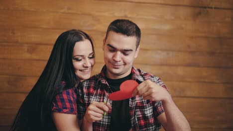 a man is carving out heart with colored paper in the arms of a beloved woman on valentine's day