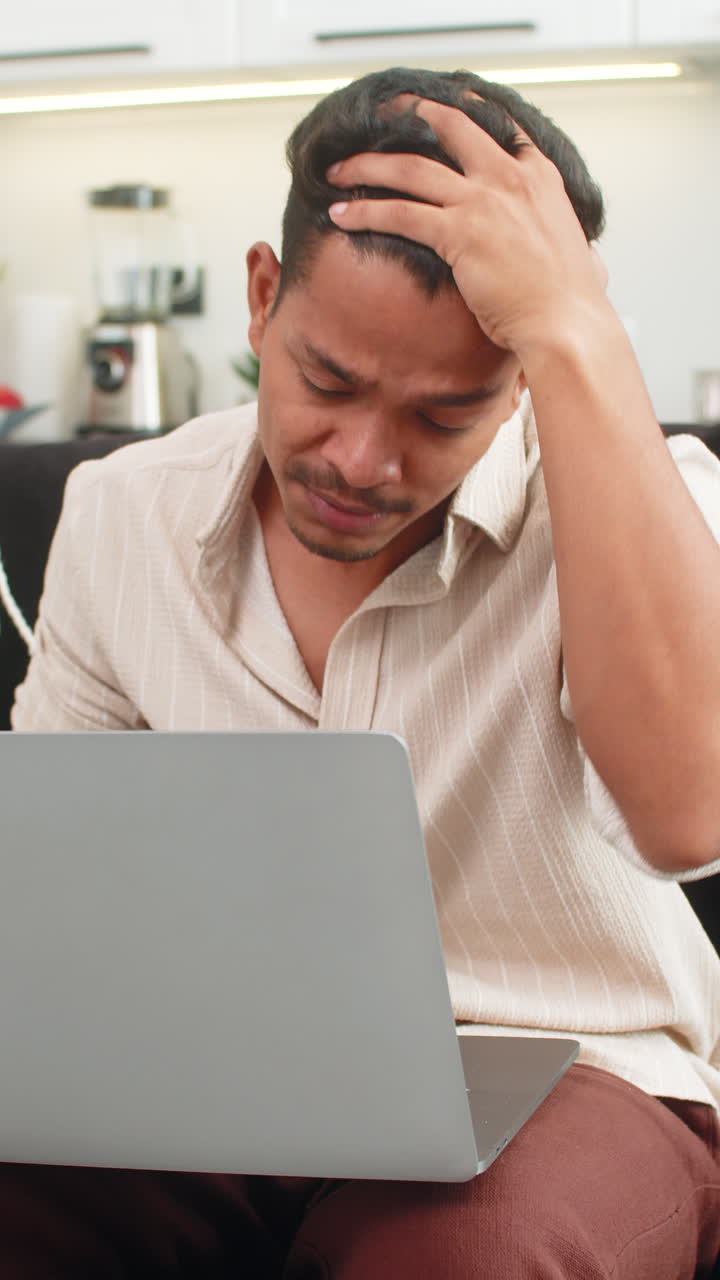 Indian man reads rejection on laptop holds head breathes deep builds step plan to improve work clear