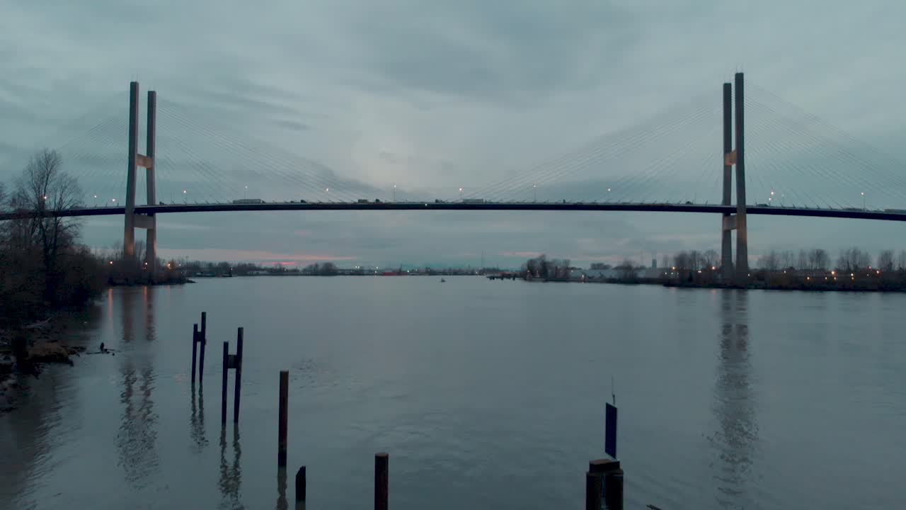 자동차와 트럭이 다리를 건너는 동안 드론 4k 영상 알렉스 프레이저 다리 현수교 현대 다리와 일몰의 낮은 각도 샷