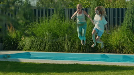 women and children jumping into a pool in a backyard garden