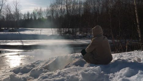 Retrato-Del-Hombre-Por-La-Corriente-Del-Río-Congelado,-Sobreviviendo-En-La-Naturaleza-Salvaje-Del-Invierno