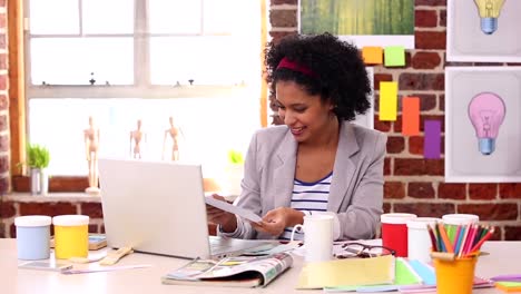 Pretty-designer-working-at-her-desk-with-laptop