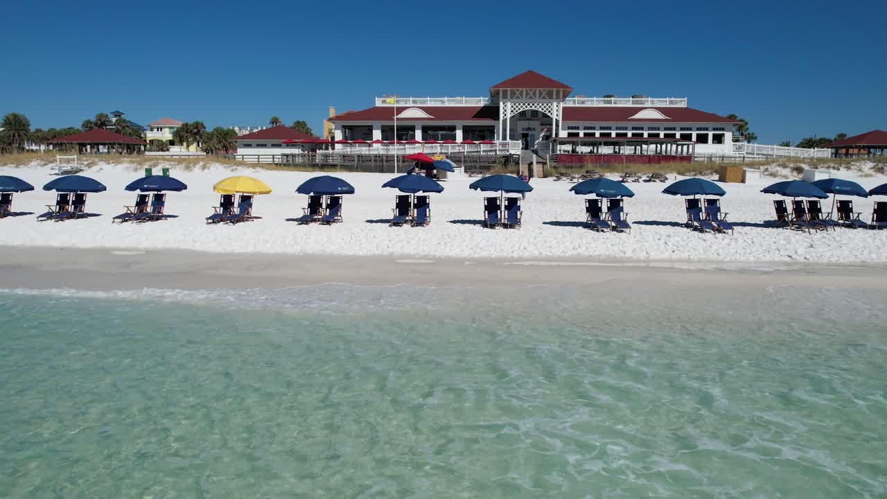 데스틴 비치 걸프 코스트 팬핸들 플로리다 백사장에 있는 파란 우산 맑고 에메랄드빛 바다가 드론 조감도로 날아가는 밝고 화창한 날