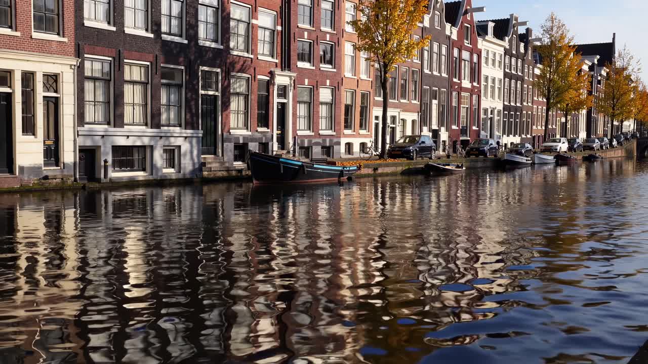 Scenic canal view showcases charming architecture and vibrant autumn foliage, capturing the tranquil essence of a picturesque waterfront scene