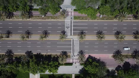 vista estática de arriba hacia abajo de los peatones que cruzan una gran calle concurrida