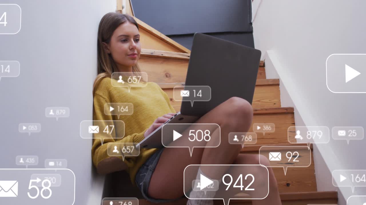 animación de iconos de redes sociales sobre una mujer caucásica usando una computadora portátil sentada en las escaleras de su casa