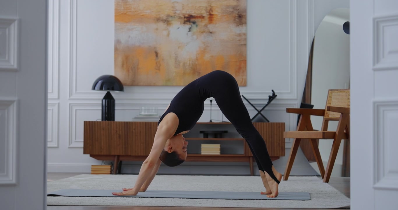 Junge Frau macht Yoga und dehnt sich auf der Matte zu Hause