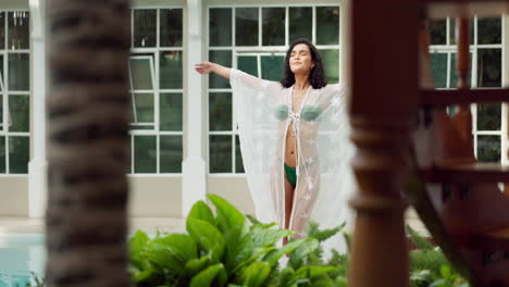 woman in bikini and cover-up by the pool