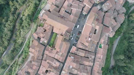 top down aerial drone view of the hilltop medieval town of pitigliano, tuscany in morning light, with red tile roofs and old buildings, in 4k
