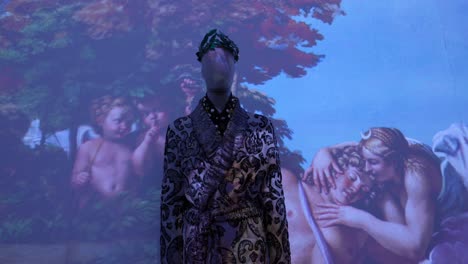 an ornate gown displayed on a mannequin in front of an artistic animation
