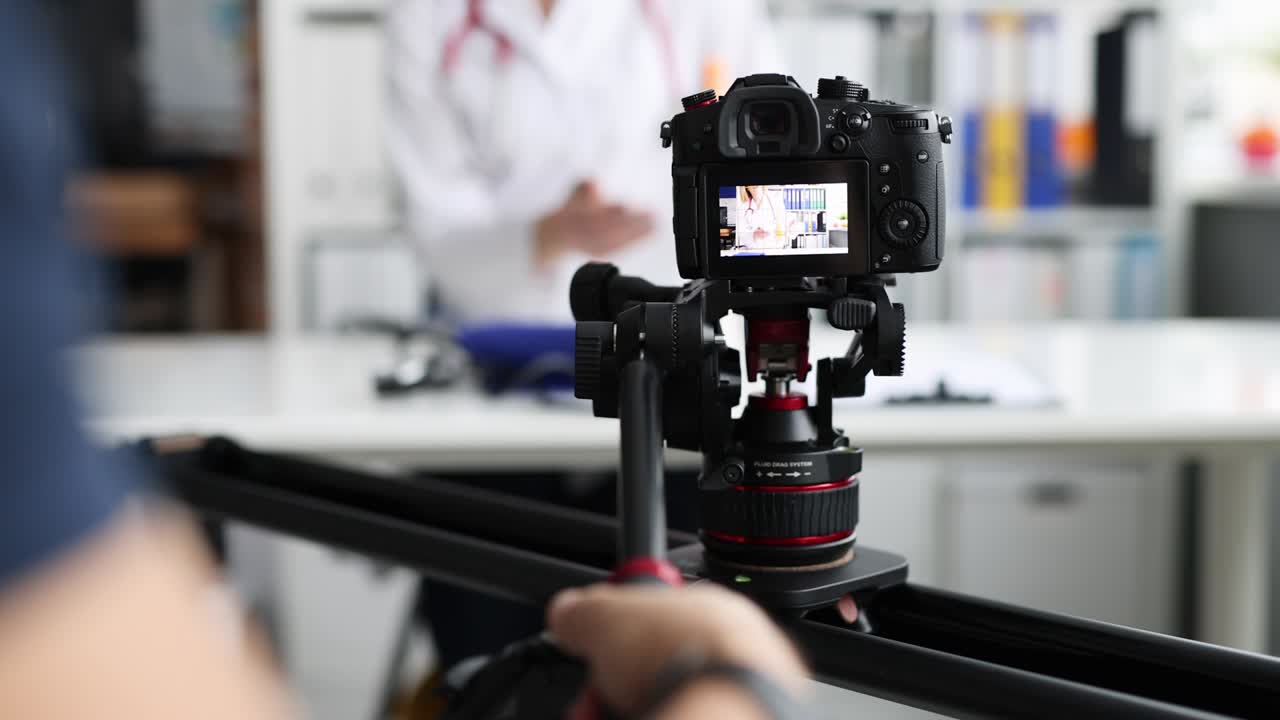 사진작가가 3단과 슬라이더를 사용하여 카메라에 의사를 촬영하는 4k 영화