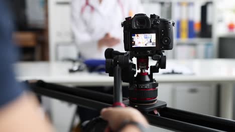 fotógrafo filmando al médico en la cámara usando un trípode y un deslizador en primer plano película en 4k