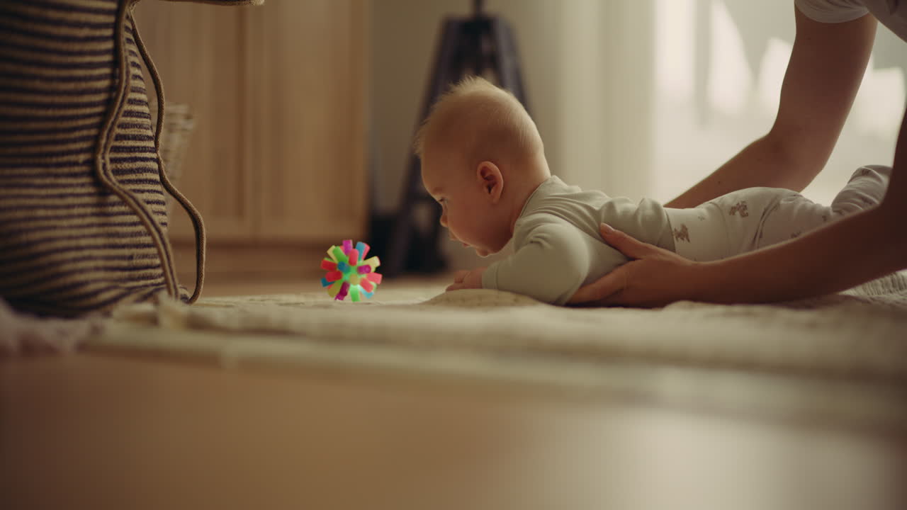 Baby playing with toy with mother's support