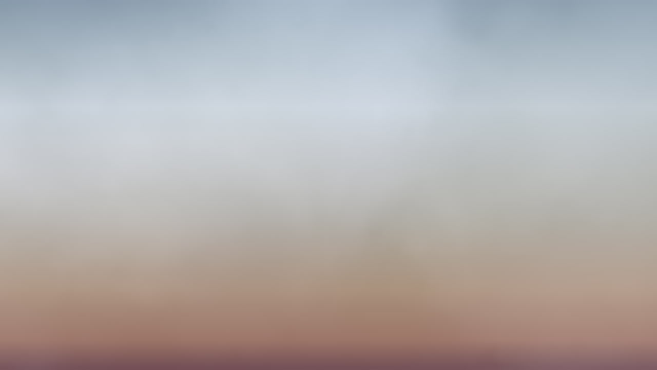 paisaje vibrante borroso en primer plano con amarillo, azul y verde contra un cielo azul con nubes blancas esponjosas