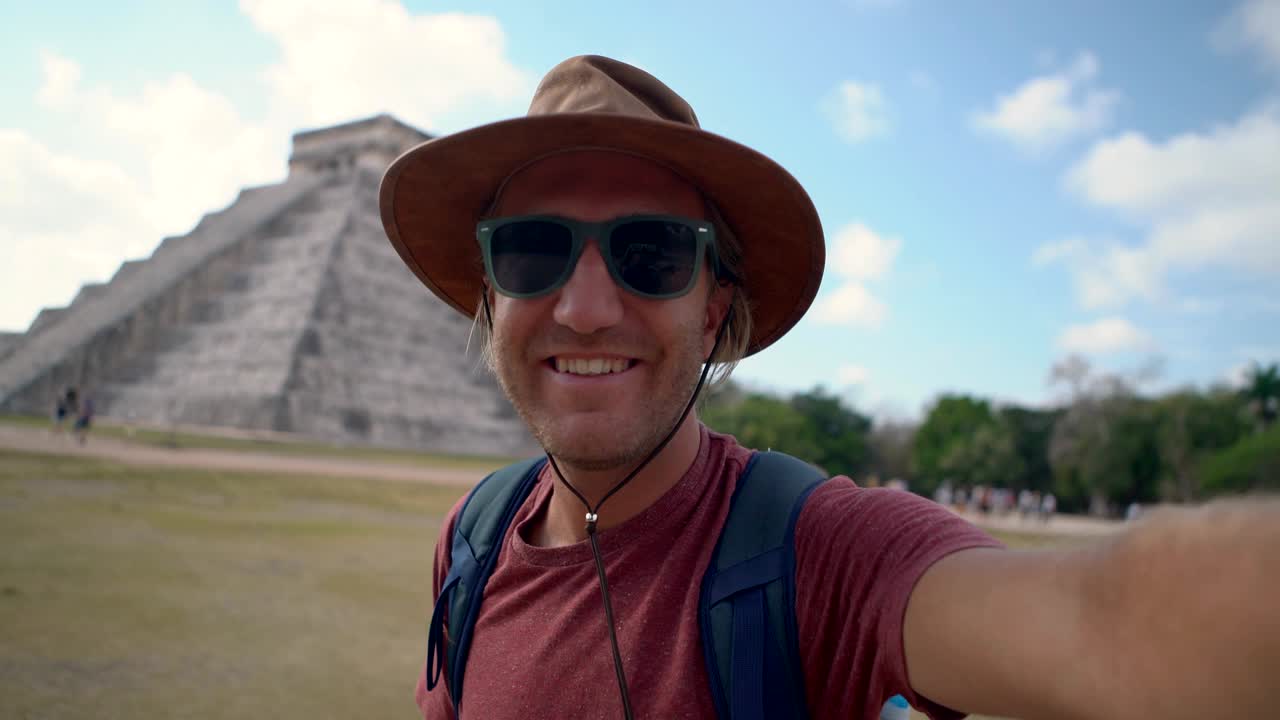 un tipo genial tomando un retrato de selfie en méxico frente a la pirámide maya. un joven video selfie con un antiguo templo. concepto de conexión de personas de viaje