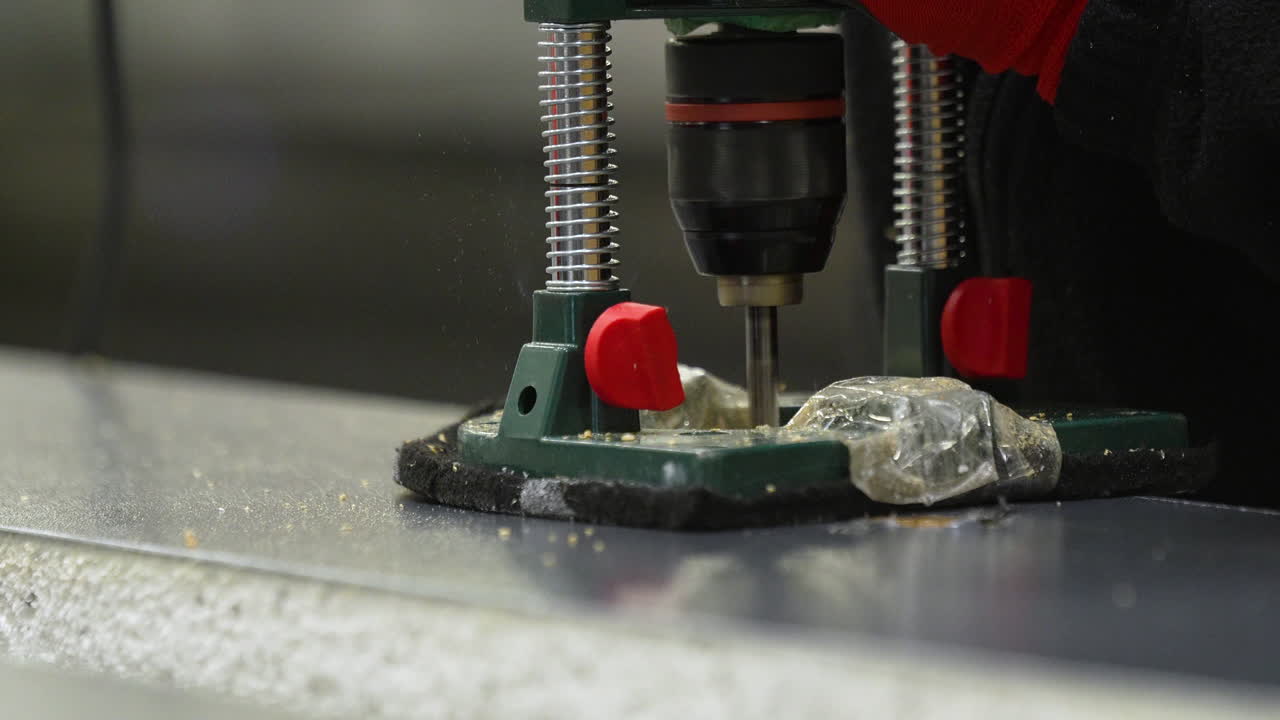 Gros plan sur une perceuse à colonne professionnelle perçant une planche en bois dans un environnement d'usine. Idéal pour le contenu lié à la menuiserie, à la fabrication et à l'industrie de la construction.