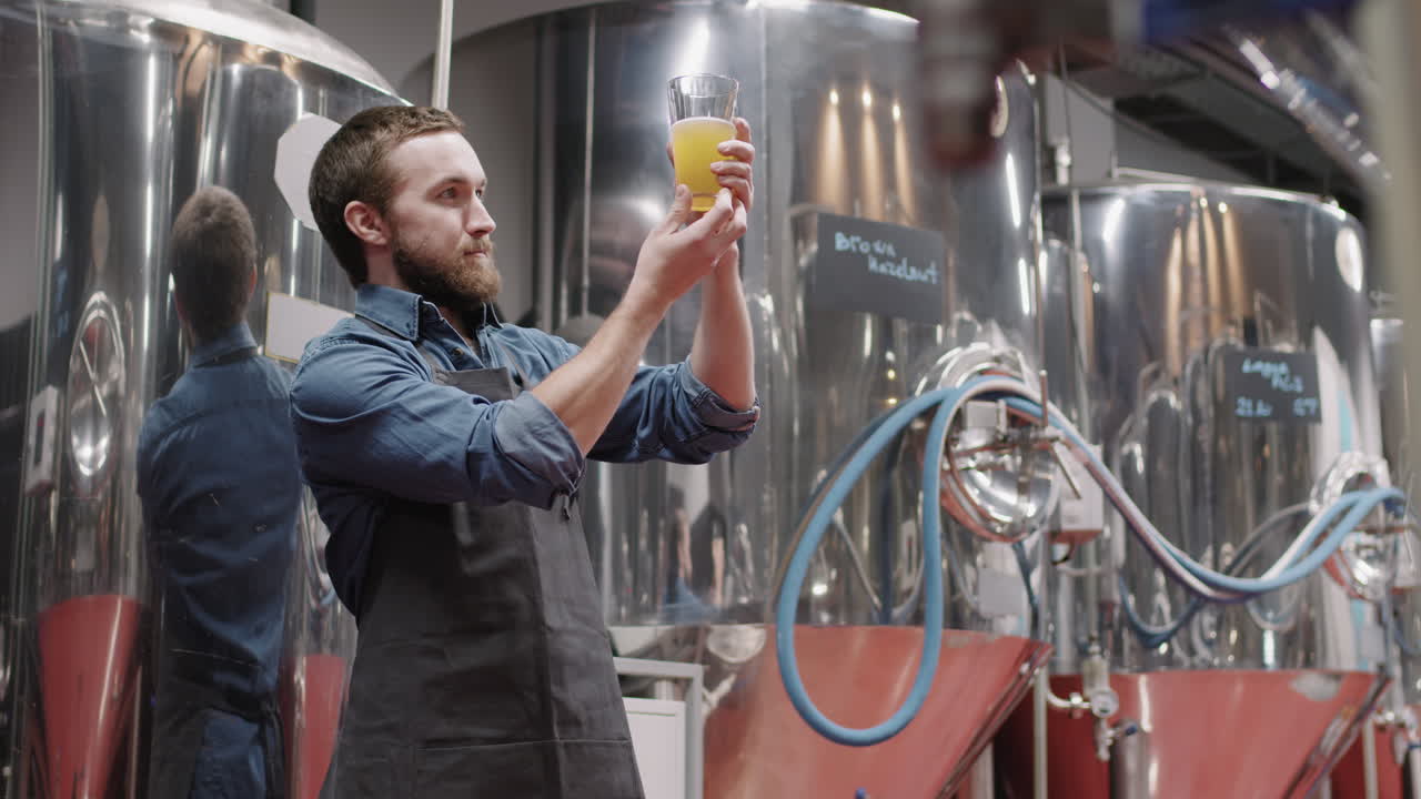 Brewery Worker With Glass Of Beer At Factory