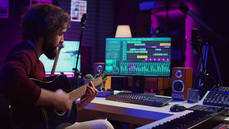 musical performer recording guitar sounds for a new track in home studio