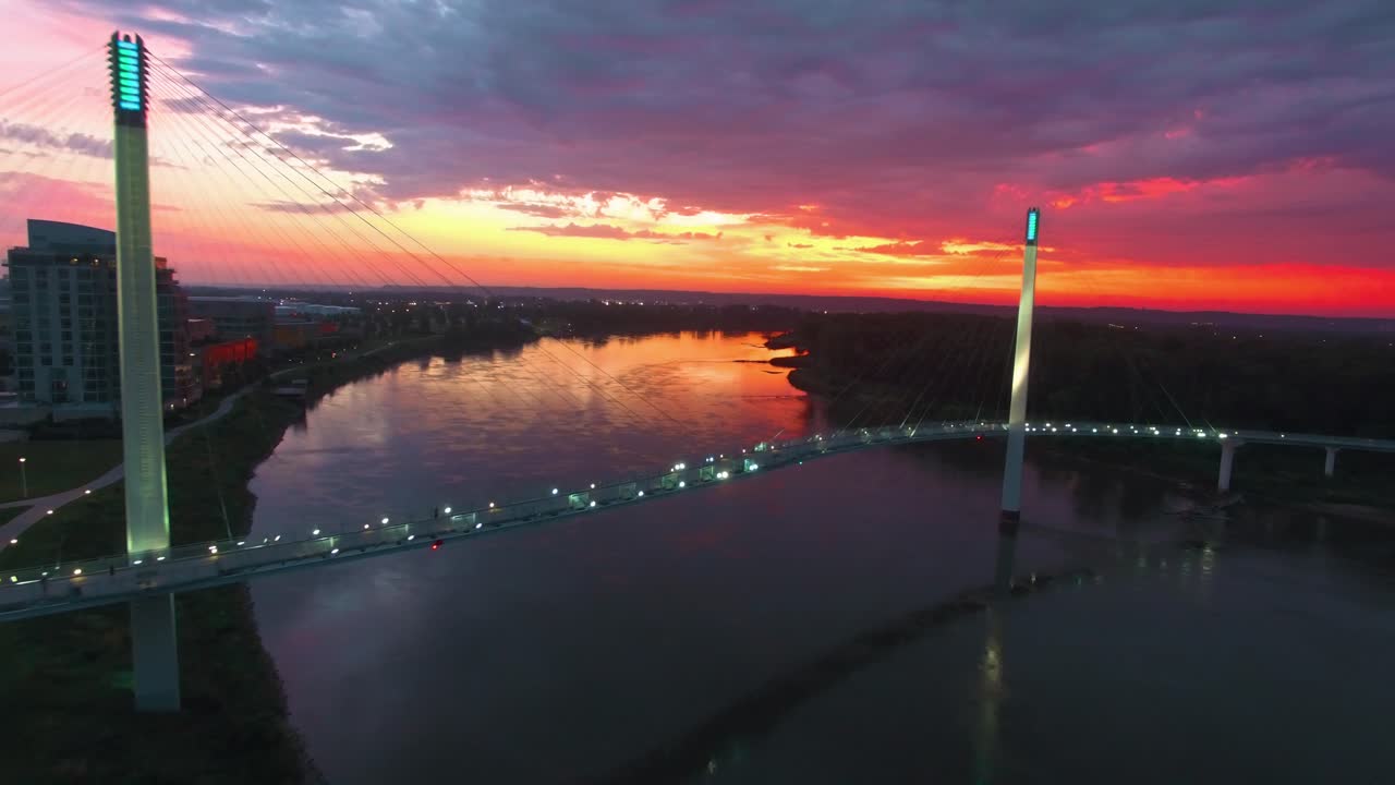 Fly away of male runner crossing bridge during colorful sunrise