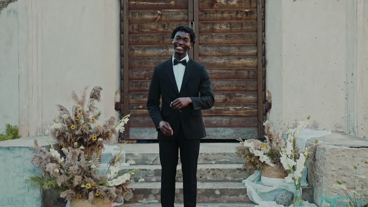 Black man dressed as a groom smiling on his wedding day