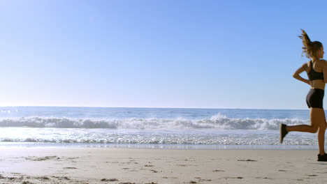 fit woman jogging in the beach 4k