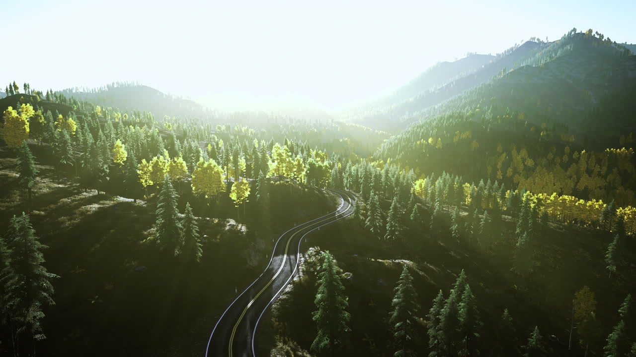 Scenic view of winding train tracks through lush green mountains at sunrise