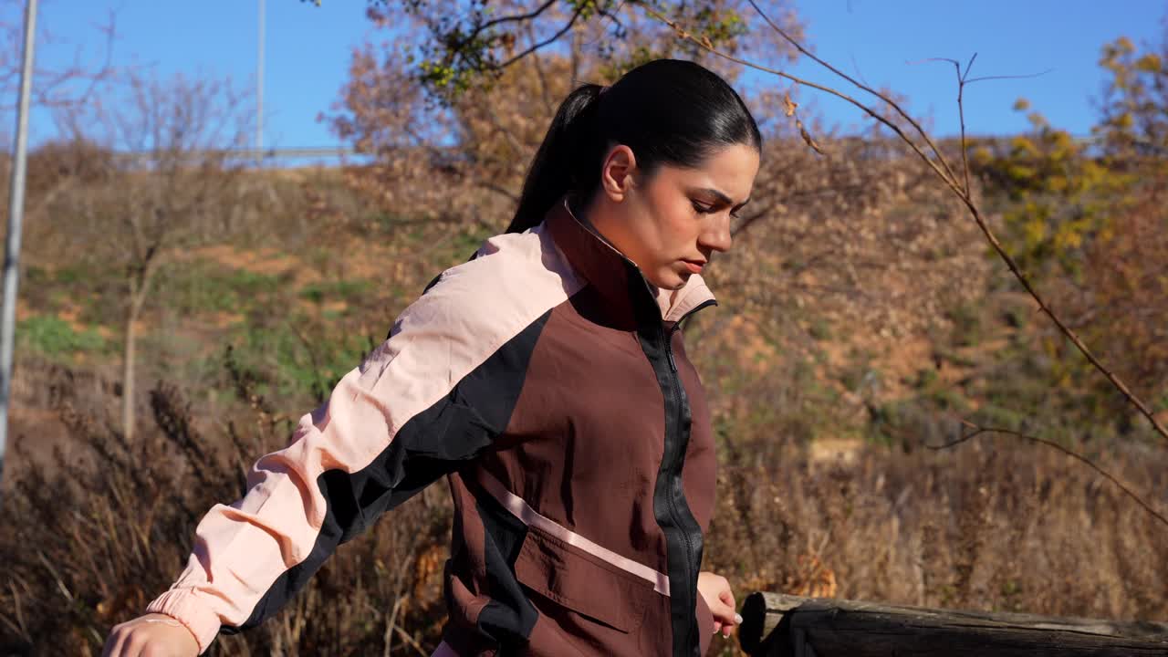 Athletic woman in sportswear stretching triceps in the park. Close up