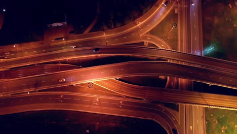 Vista-Aérea-Nocturna-De-Una-Intersección-De-Autopistas-Con-Senderos-De-Tráfico-En-Moscú-Nocturna