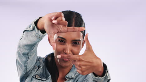 Hand,-woman-and-face-with-picture-frame-in-studio