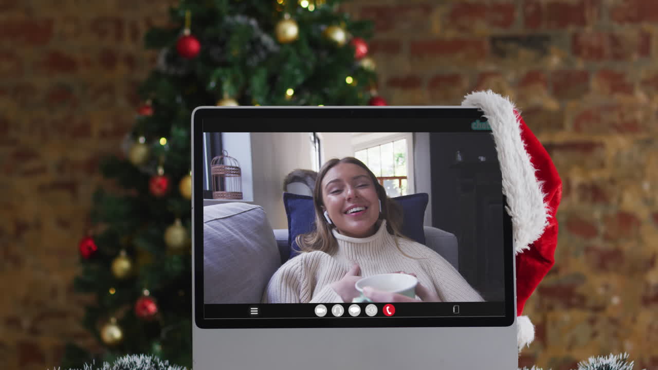 mujer caucásica feliz en videollamada en computadora portátil, con decoraciones de navidad y árbol