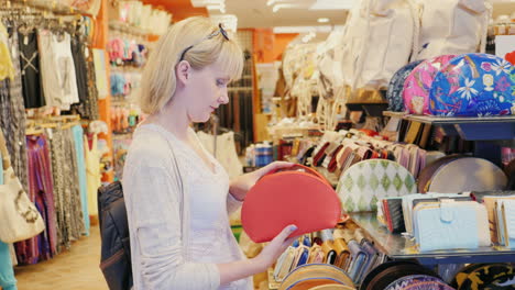 a woman chooses a bag in a shop on the beach