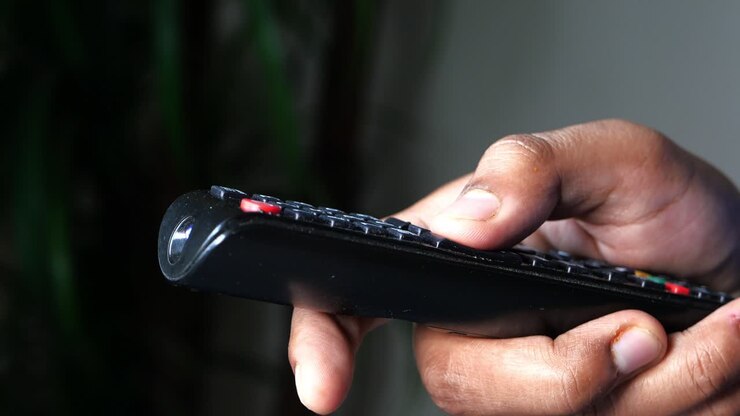Mano che tiene un telecomando della TV