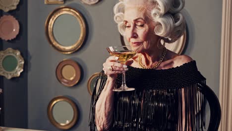 glamorous senior woman savoring cocktail in vintage dressing room, embodying sophisticated elegance while enjoying personal moment of relaxation and timeless beauty