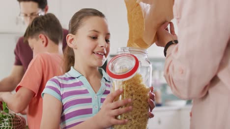 happy caucasian family unpacking bags with pasta