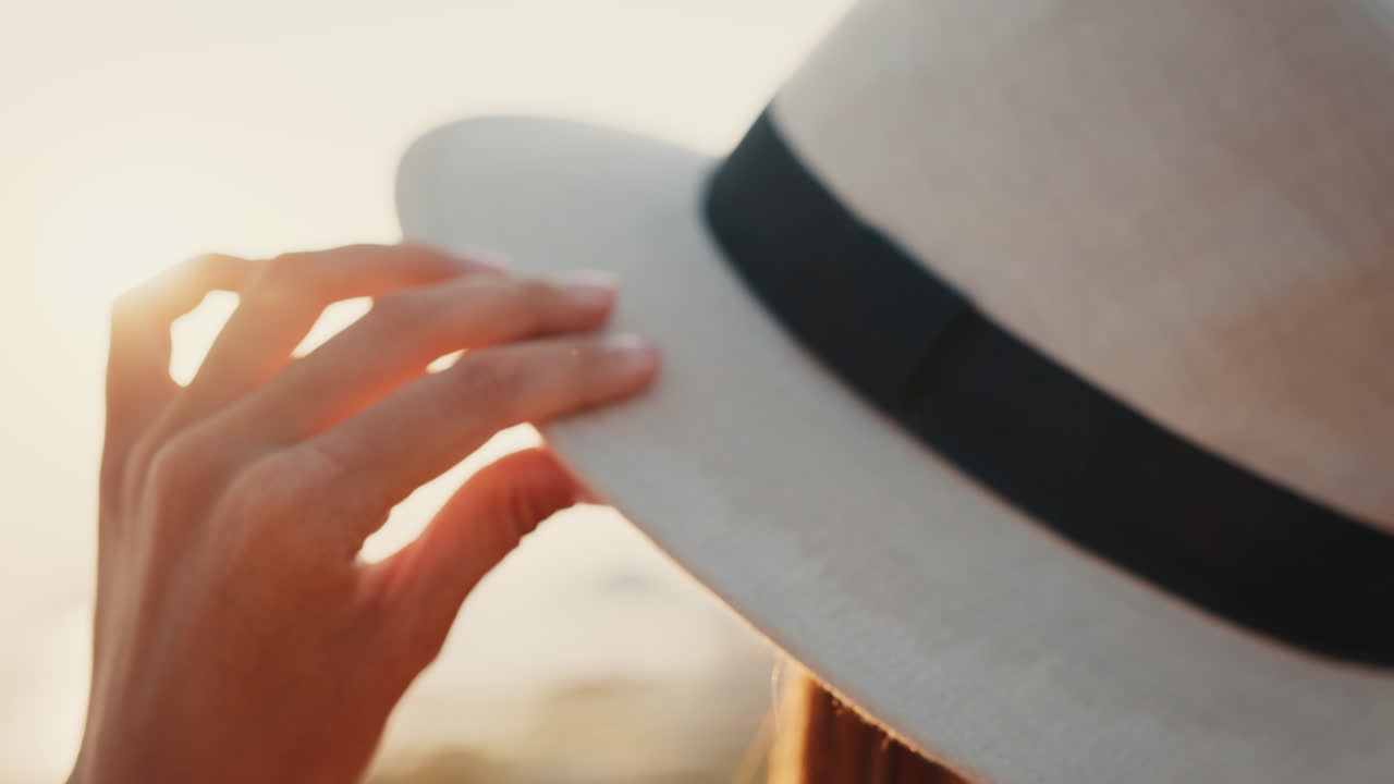 mujer con un sombrero al atardecer
