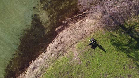 Shot-from-above-from-man-walking-his-dog-in-a-park