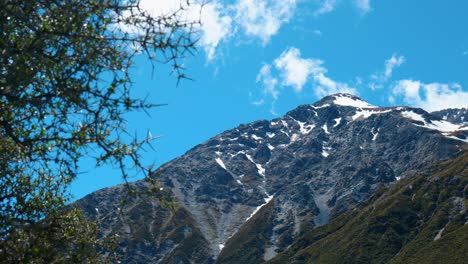 picos cubertos de nieve: montaña con manchas de nieve a través de arbustos en cautivadoras imágenes de stock