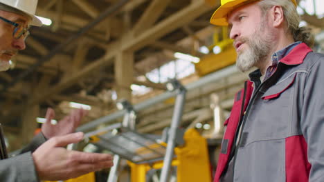 engineer and factory worker shaking hands and talking