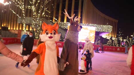 pista de patinaje sobre hielo con trajes de animales en el mercado de navidad