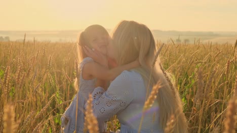 mother and child in a wheat field at sunrise