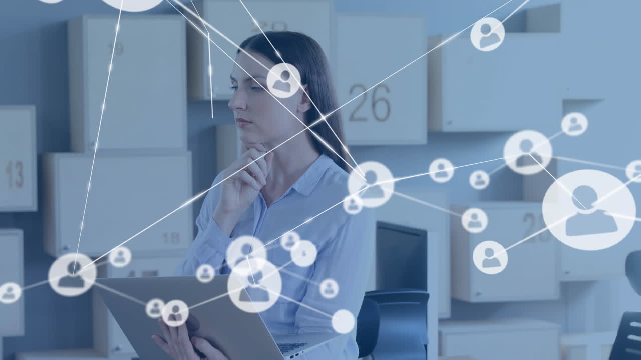 анимация сети соединений с иконами над кавказской бизнесменкой, использующей ноутбук в офисе