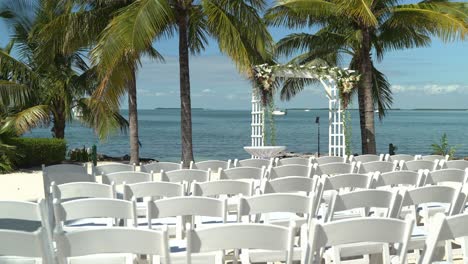 panning lento lugar de la boda en la playa en un día soleado con paz y tranquilidad asientos al aire libre playa de arena asientos de compromiso con mesas