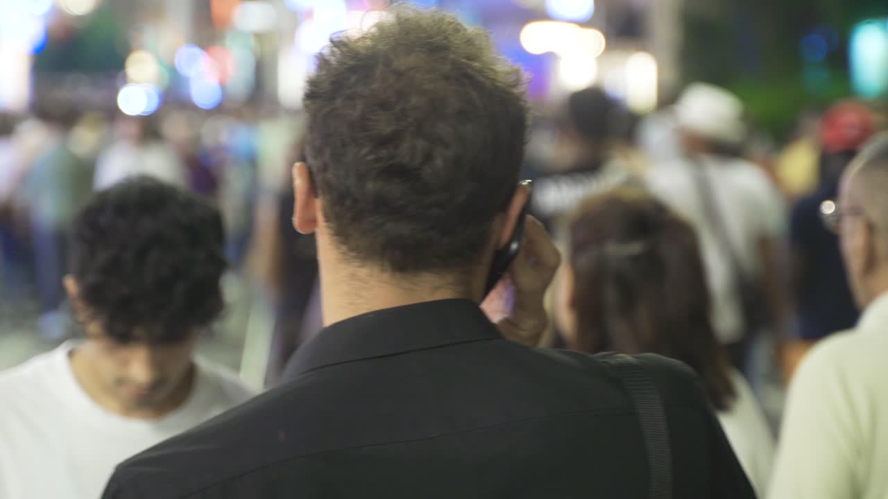 나이트 스트리트에서 전화로 이야기하는 젊은 남자.